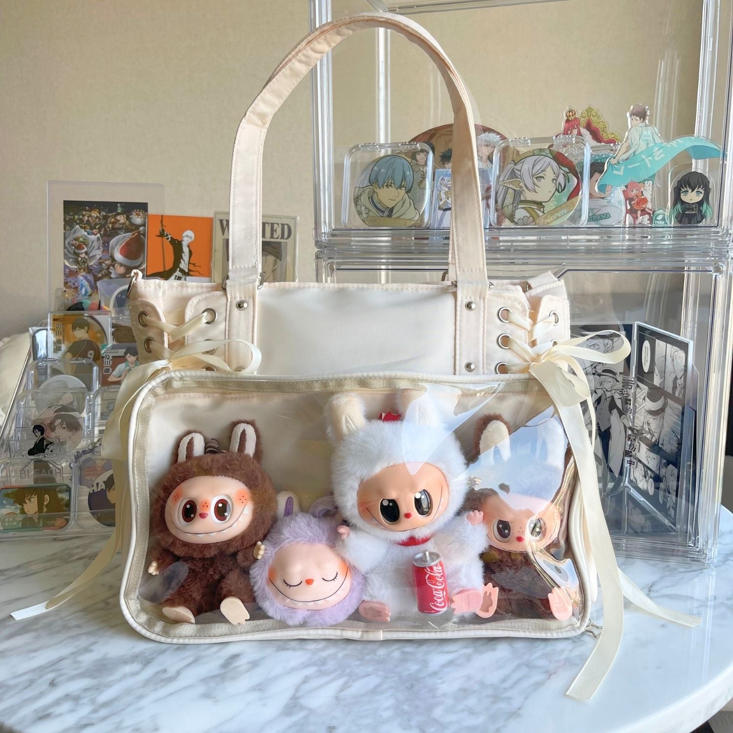 white cream ita bag on table with Labubu plushies arranged inside clear window