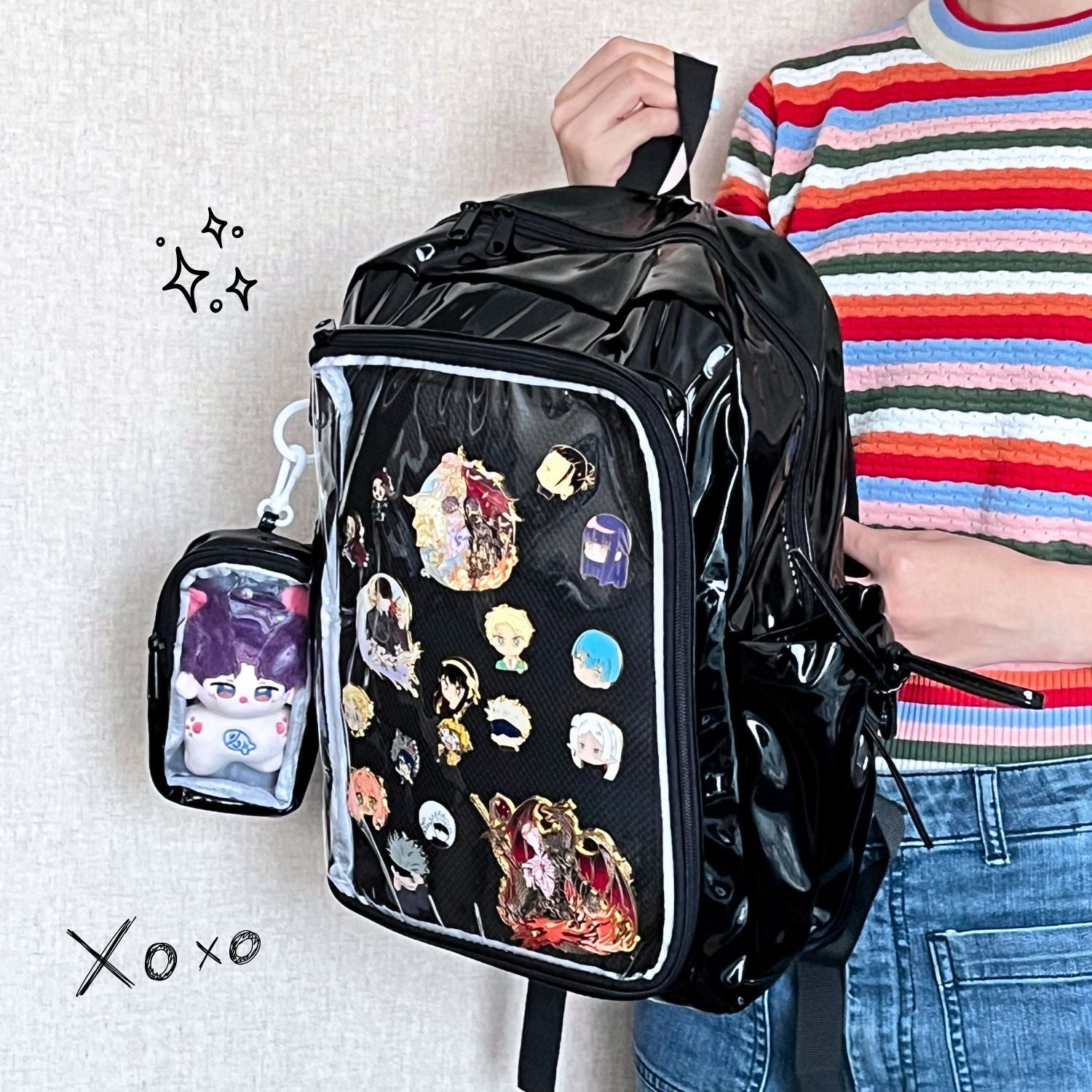 model holding super large ita backpack featuring enamel pin display and plushie arrangement